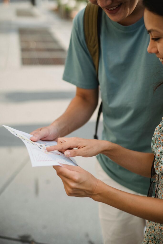 Smiling couple navigating with map on city street